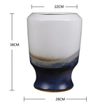 Vase en céramique de forme élégante avec un dégradé de couleurs grise, blanche et bleue.