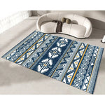 Tapis au motif géométrique bleu et jaune, avec des formes triangulaires et rectangulaires, disposées de manière symétrique sur un sol blanc.