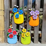 décoration murale artisanale fleurs colorées feuilles vertes abeille bleu jaune orange violet