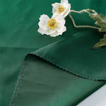 Un beau bouquet de fleurs blanches avec un centre jaune se détache sur un fond vert foncé.