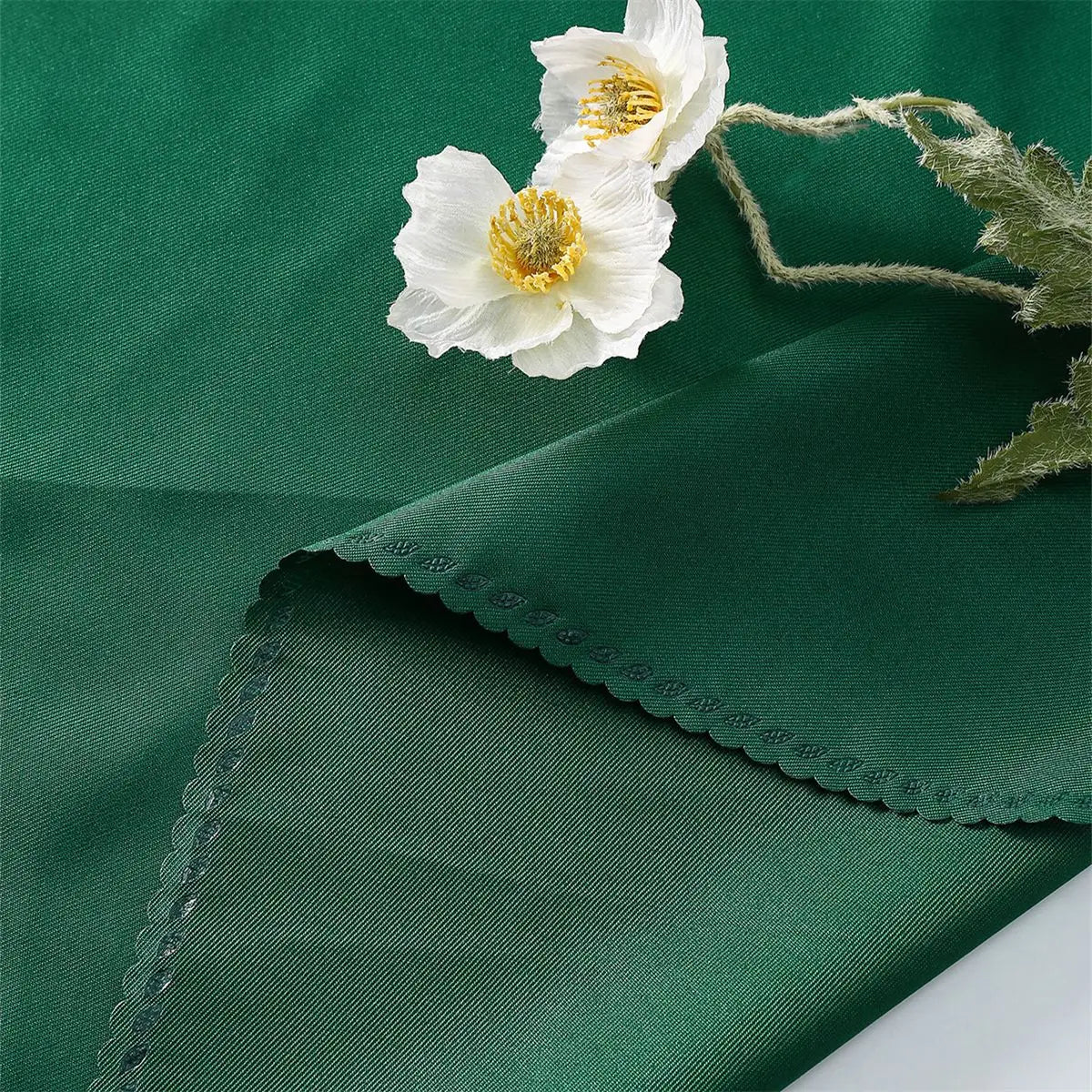 Un beau bouquet de fleurs blanches avec un centre jaune se détache sur un fond vert foncé.