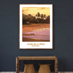 Paysage tranquille de la plage de la Perle à Guadeloupe avec palmiers et coucher de soleil doré reflété sur l'eau.