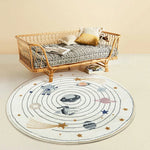 Chambre d'enfant confortable avec un canapé en rotin et un tapis rond décoré de motifs d'espace.