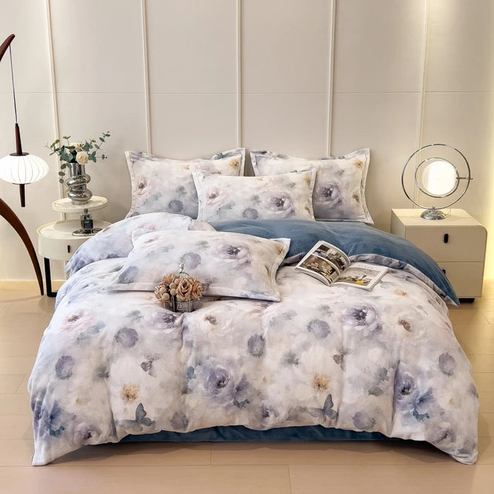 Lit douillet avec une parure de lit florale blanche et grise, avec des oreillers assortis, posé sur un sol blanc brillant, entouré de tables de chevet blanches et d'un éclairage tamisé, créant une atmosphère apaisante et confortable dans cette chambre.