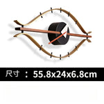 horloge murale forme œil moderne or marron foncé aiguilles rouge blanche minimaliste
