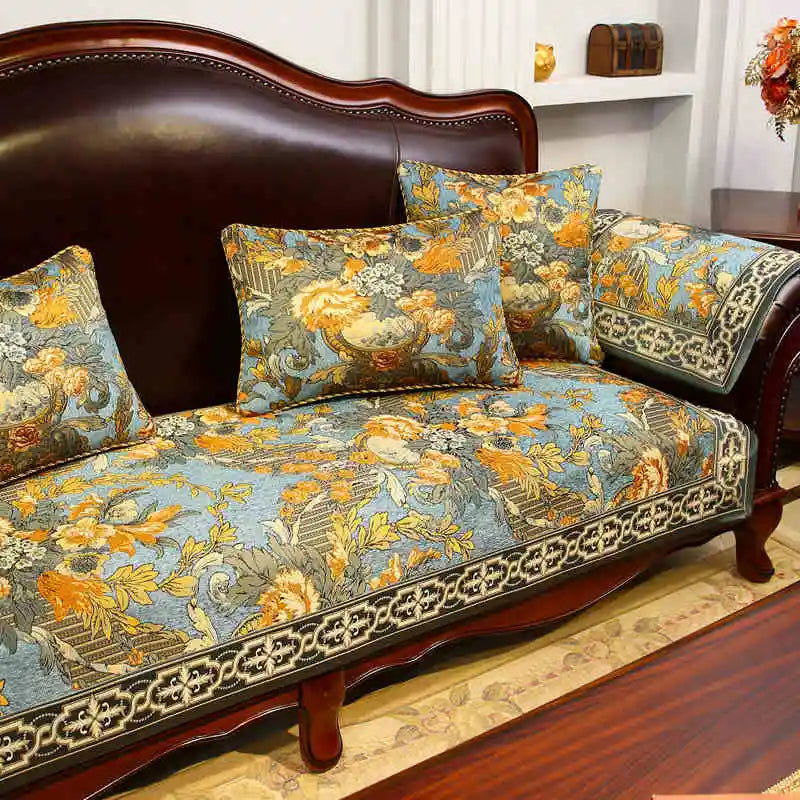 Mobilier de luxe avec un canapé en bois sombre et des coussins ornés de motifs floraux colorés dans des tons d'oranges, jaunes et bleus, créant une atmosphère chaleureuse et élégante.