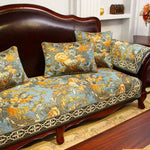 Mobilier de luxe avec un canapé en bois sombre et des coussins ornés de motifs floraux colorés dans des tons d'oranges, jaunes et bleus, créant une atmosphère chaleureuse et élégante.