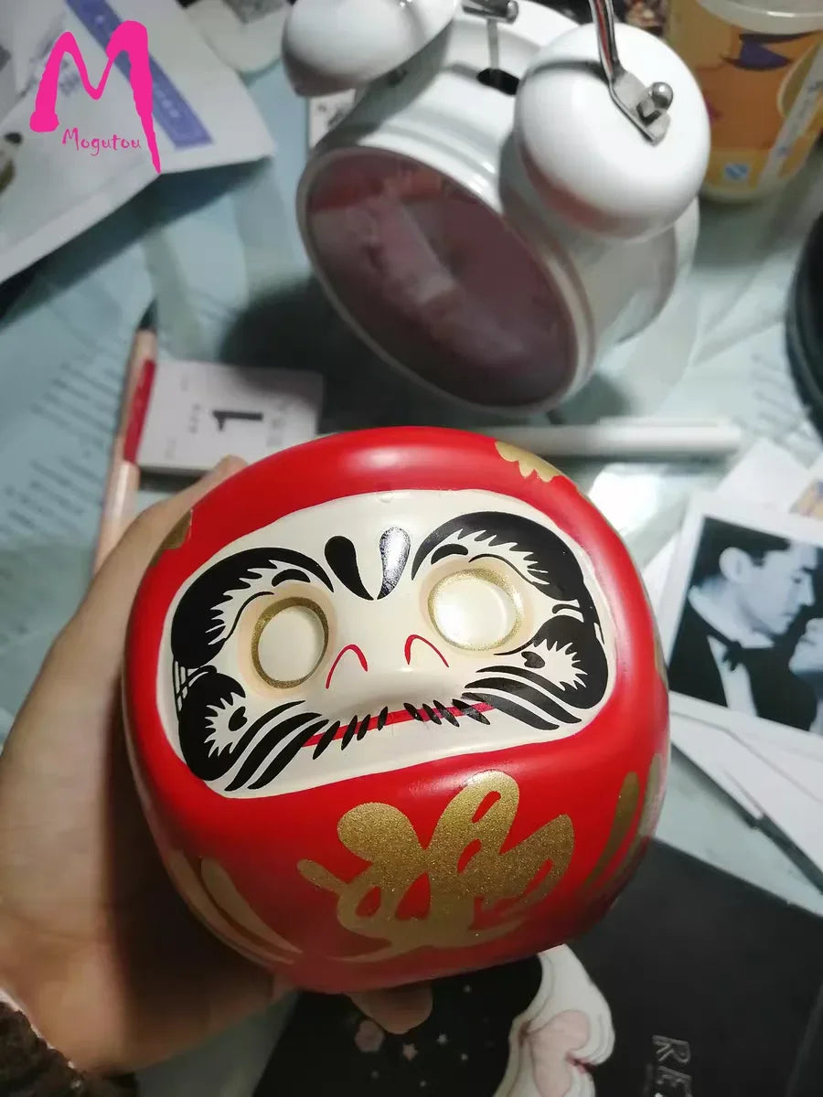 statuette japonaise daruma rouge blanche visage sourire yeux grands ouverts motifs dorés traditionnels décoration