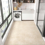 Intérieur moderne d'une buanderie avec machine à laver et rangements, sol en carrelage beige à motifs graphiques, et murs blancs avec étagères décoratifs.