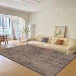 Un intérieur lumineux et confortable avec un grand canapé beige, un tapis moelleux et des décorations minimalistes créant une atmosphère sereine et apaisante.