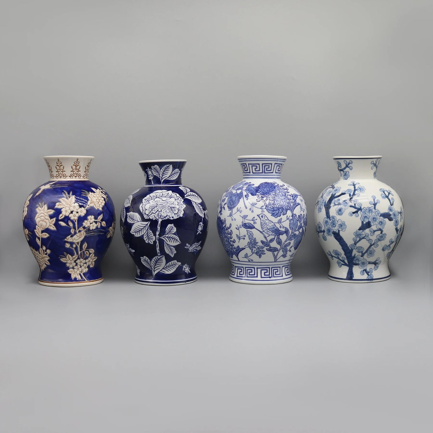 Quatre vases en céramique bleue et blanche ornés de motifs floraux et de motifs géométriques.