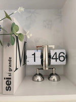 horloge numérique moderne horloge pieds boules chiffres noirs fond blanc métal brillant minimaliste affichage