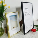 Cadre photo en aluminium posé sur un bureau avec un certificat