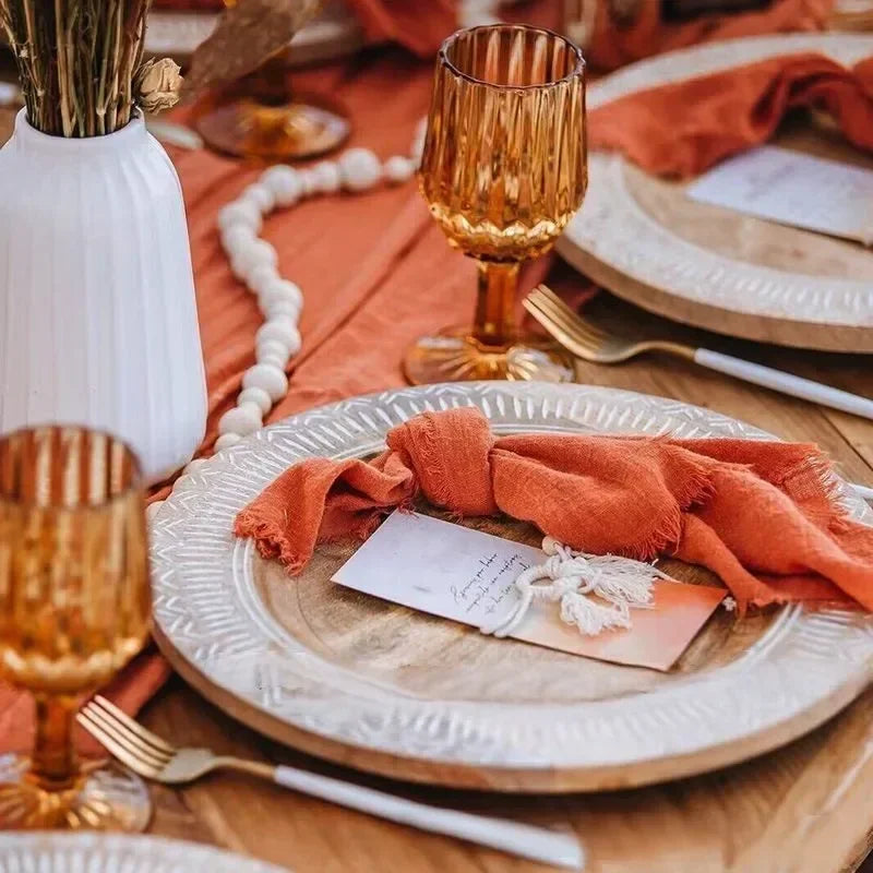 serviette table carrée orange franges moderne élégante fourchettes cuillères assiettesbranches séchées guirlande bougie parfumée