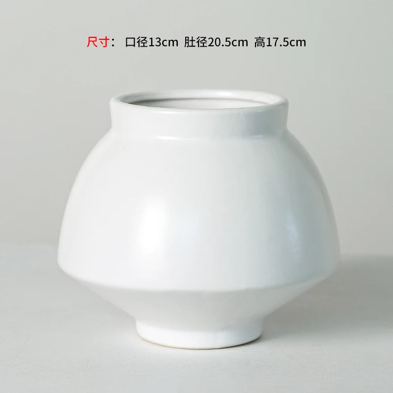 Un vase en céramique blanche de forme ronde avec des dimensions de 13 cm de diamètre, 20,5 cm de largeur et 17,5 cm de hauteur.
