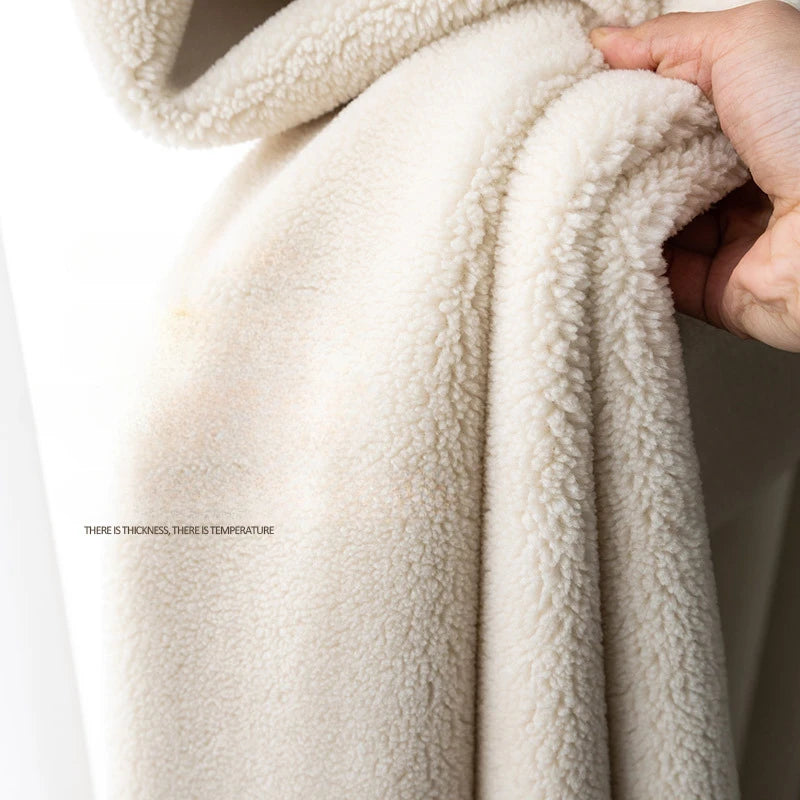 Image d'un tissu doux et épais, idéal pour concevoir des vêtements chauds et confortables. Son aspect moelleux offre une sensation de chaleur et de bien-être, parfait pour la saison froide. Le tissu est présenté dans une teinte crème élégante, mettant en valeur sa texture douillette.