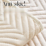 Gros plan sur une texture douce et moelleuse de tissu blanc rayé, avec le texte "Anti-skid" imprimé en surbrillance.