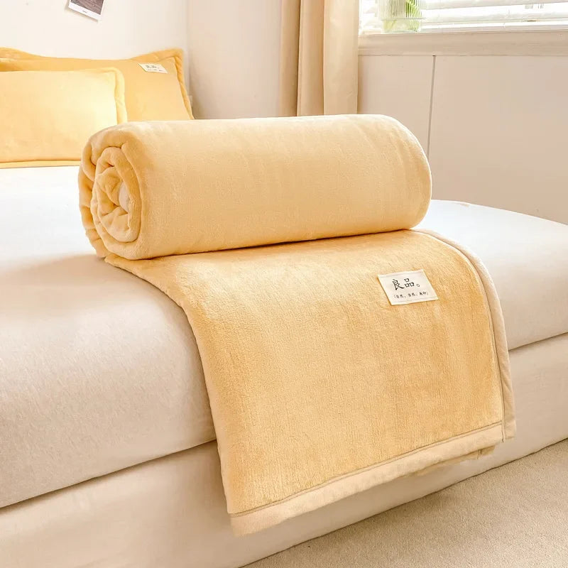 Une couverture douce et confortable repose sur un lit dans une chambre lumineuse et élégante.