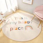 Ce tapis rond représente un endroit heureux avec un arc-en-ciel coloré et un texte positif.