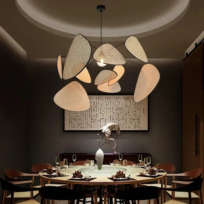 Lustre moderne pendentif LED avec écran feuille grille en rotin fait main suspendu dans un salon