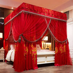 Lit de mariage somptueux aux rideaux rouges ornés de motifs dorés, rehaussé de franges et de décorations luxueuses, créant une atmosphère chaleureuse et élégante dans la chambre.