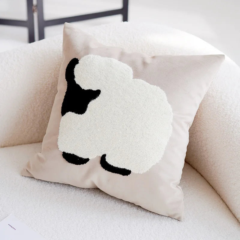 Coussin décoratif blanc et noir avec un motif de tête de mouton.