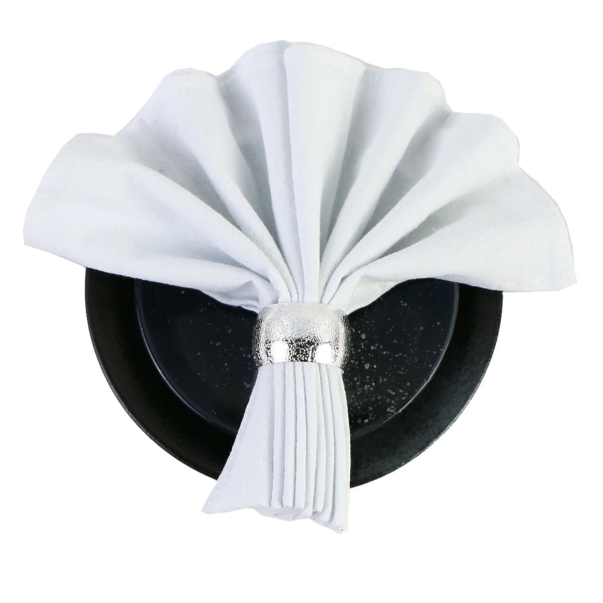Serviette blanche pliée et posée sur un fond noir avec un ornement métallique brillant.