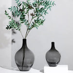 Vase en verre transparent grand ventre noir sur table de salon