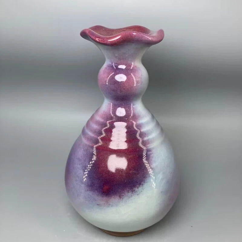 Vase vintage de forme arrondie en céramique avec une texture et une couleur violette et rose, une forme fluide et ondulée.