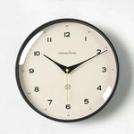 horloge murale quartz aiguille sourdine salon minimaliste visage unique fond blanc numéros noirs cadre