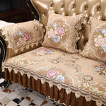 Élégant ensemble de coussins et de couverture de canapé ornés de motifs floraux élaborés sur un fond beige, avec de magnifiques bordures en dentelle ajoutant une touche de sophistication à ce décor intérieur chaleureux et raffiné.