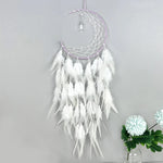 Attrape-rêves blanc et mauve suspendu, composé de plumes, d'un croissant de lune et de perles, décoration murale élégante et apaisante.