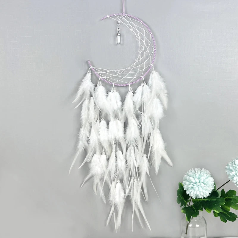 Attrape-rêves blanc et mauve suspendu, composé de plumes, d'un croissant de lune et de perles, décoration murale élégante et apaisante.