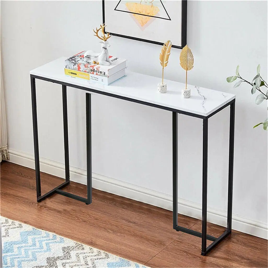table console moderne marbre blanc pieds métal noir vase fleurs lampe livre plume dorée