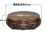 support circulaire bois sculpté artisanal traditionnel marron foncé détails complexes vase plantes décoration maison