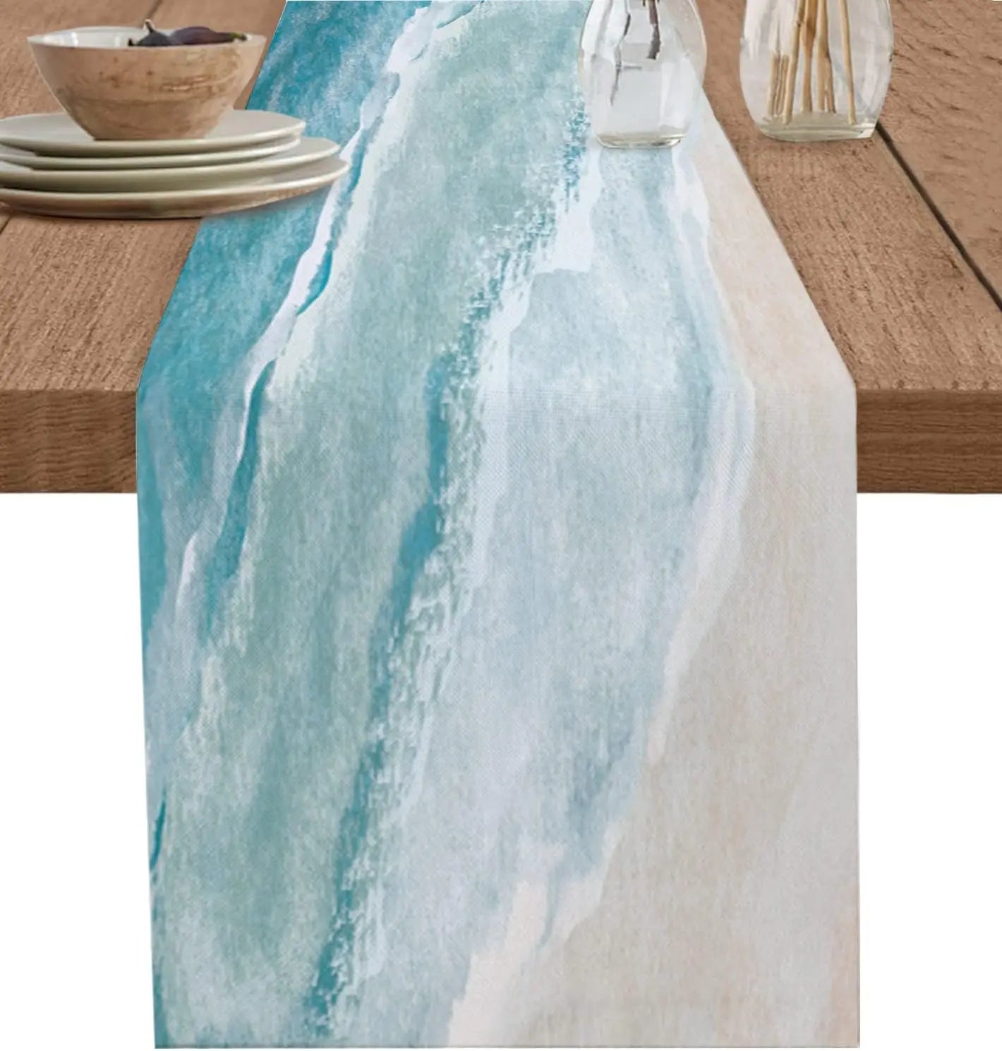 Un seau en céramique blanc et des ustensiles de cuisine sur une table en bois, avec une nappe bleu clair et blanc évoquant une scène apaisante de bord de mer.