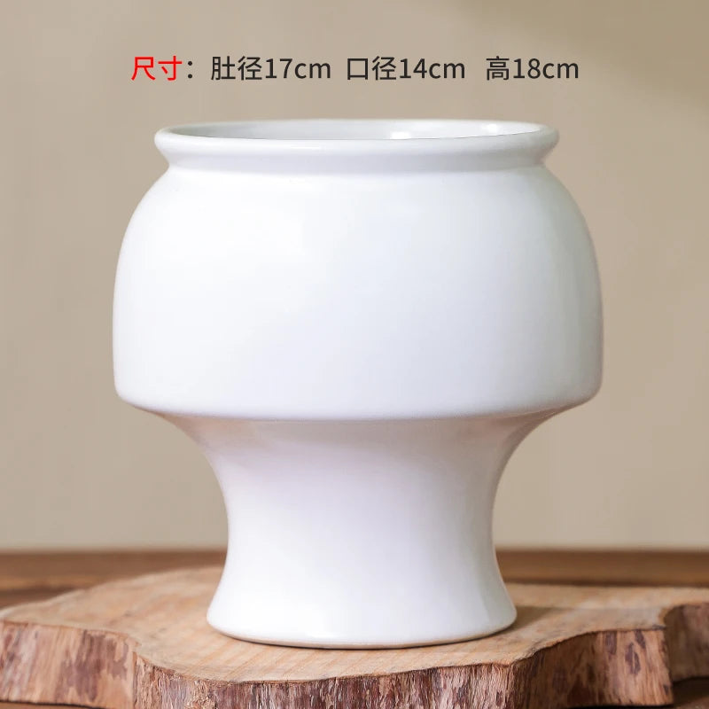 Vase de fleurs blanc simple et élégant, avec des dimensions de 17 cm de largeur, 14 cm de diamètre et 18 cm de hauteur.