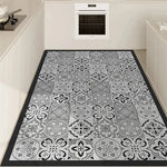 Tapis de sol motif carrelage en noir et blanc élégant et moderne, avec un design ornemental floral dans une cuisine lumineuse et épurée.