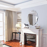 Cette pièce élégante présente un décor moderne avec des rideaux, une cheminée et un miroir décoratif, ainsi qu'une statuette de cheval sur une console.