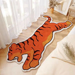 Un tapis en forme de tigre orange avec des rayures sombres, créant une décoration chaleureuse et ludique dans la pièce.