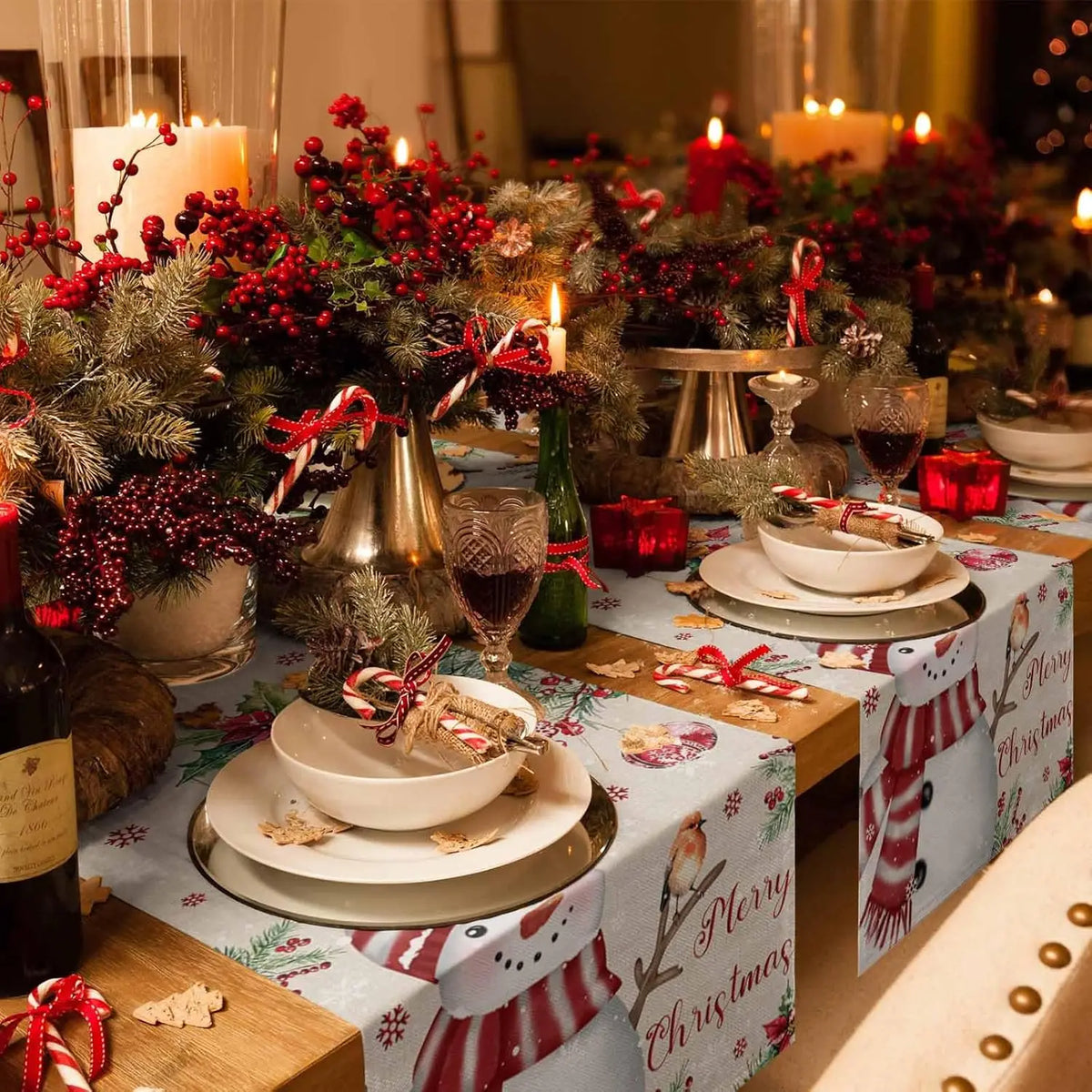 Cette image représente une table de Noël décorée de manière festive avec des bougies allumées, des branches de sapin, des baies rouges et des accessoires décoratifs, créant une ambiance chaleureuse et accueillante pour les fêtes.