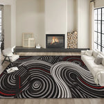 Le tapis au motif abstrait en noir, blanc et rouge au centre de la pièce accorde une touche graphique et tendance à l'ensemble, qui est complété par la cheminée et le cadre décoratif.