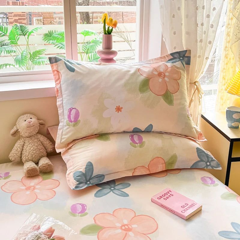 Coussins décoratifs aux motifs de fleurs colorées sur le lit, avec un lapin en peluche et des accessoires.