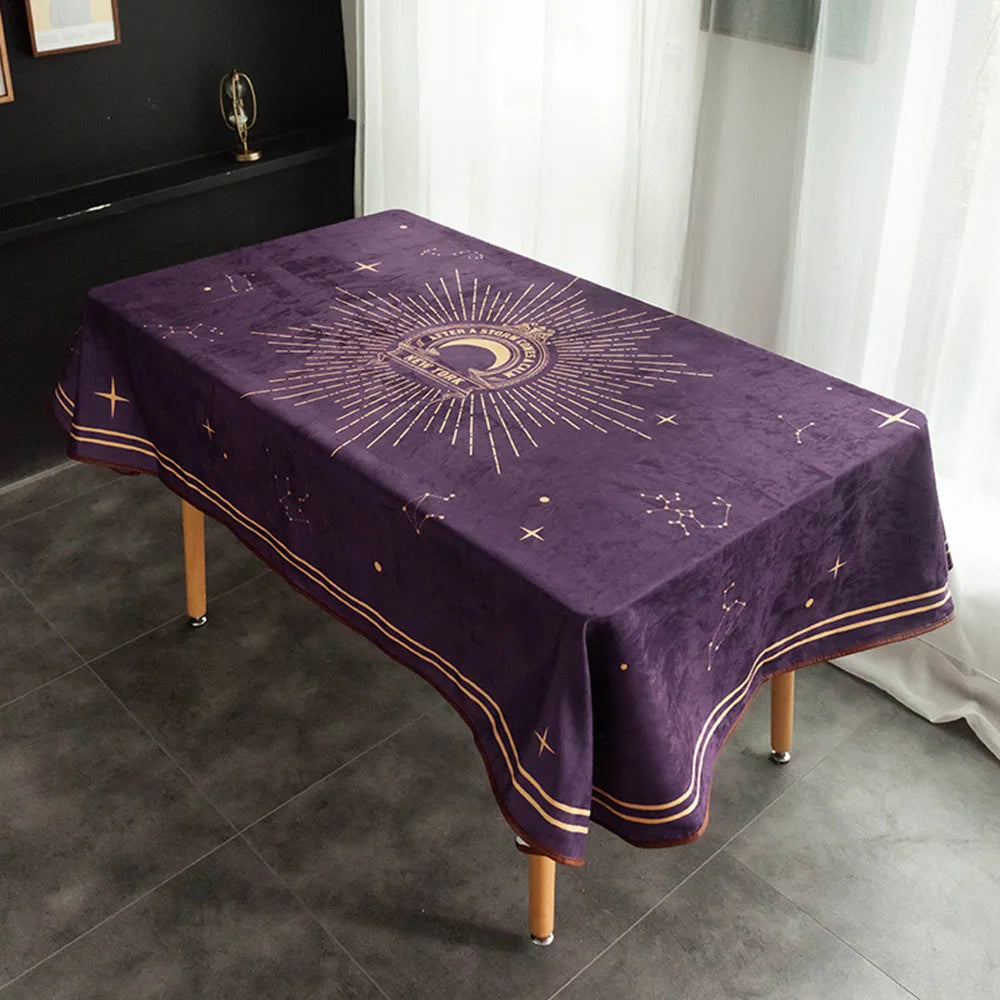 Nappe pourpre ornée d'un motif solaire doré et de symboles astrologiques, sur une table dans une pièce moderne.