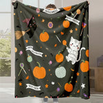 Une couverture décorée de motifs d'Halloween, incluant des chatons, des citrouilles, des étoiles et des chauves-souris sur un fond sombre.