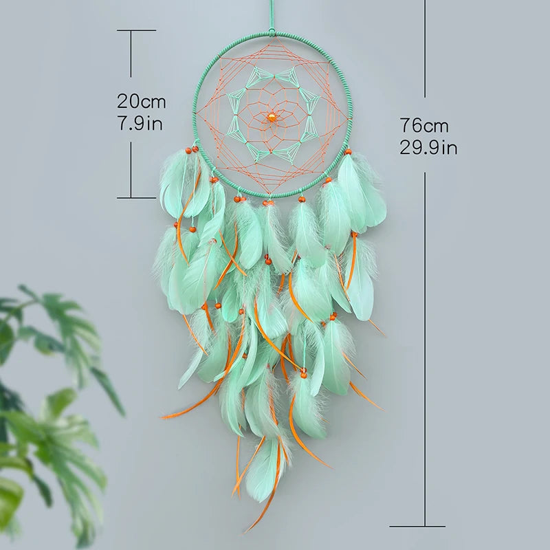 Un capteur de rêves décoratif en plumes de couleur vert menthe, mesurant 76 cm de hauteur et comprenant des perles oranges.