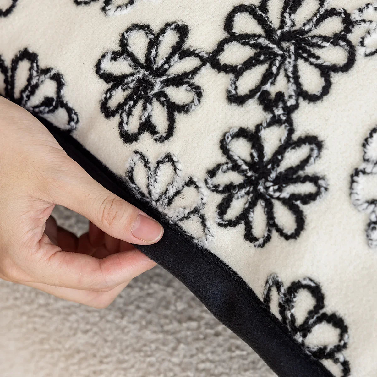 Détail d'un motif floral en noir et blanc sur un tissu doux et douillet.