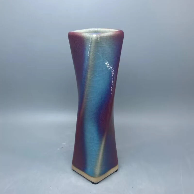 Un vase de céramique aux couleurs irisées et ondulantes, créant un effet visuel élégant et captivant.