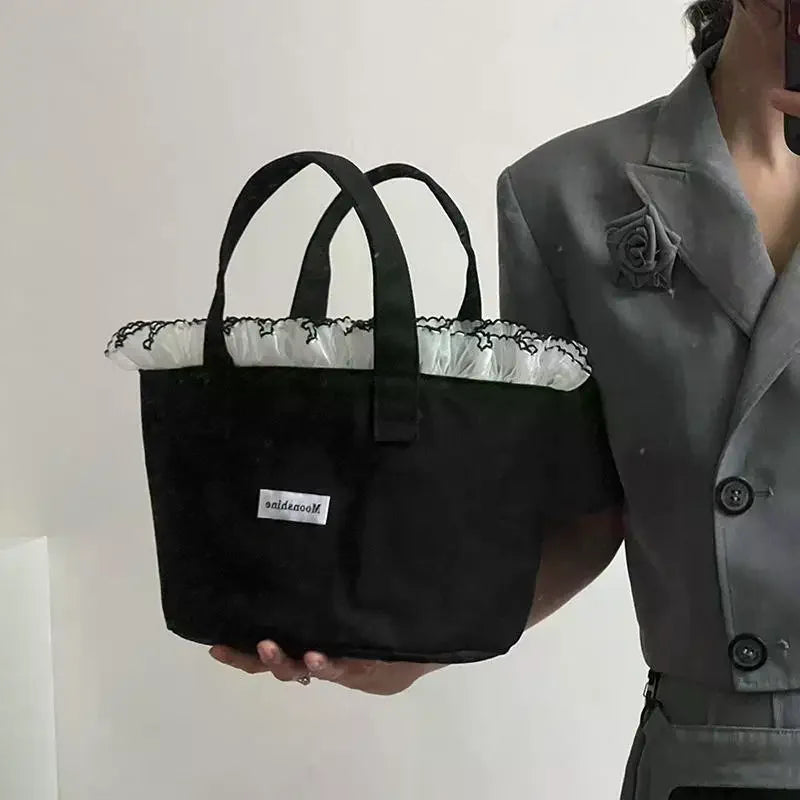 sac main femme noir texture veloutée moderne poignées étiquette logo