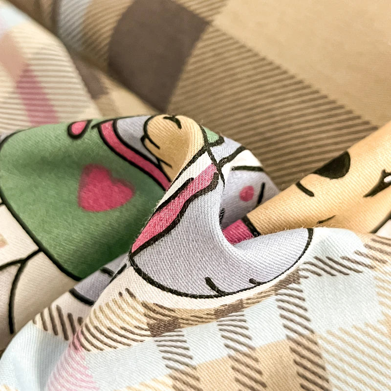 Poupée décorative en tissu avec un motif graphique coloré et whimsique, représentant une créature imaginaire aux traits expressifs.